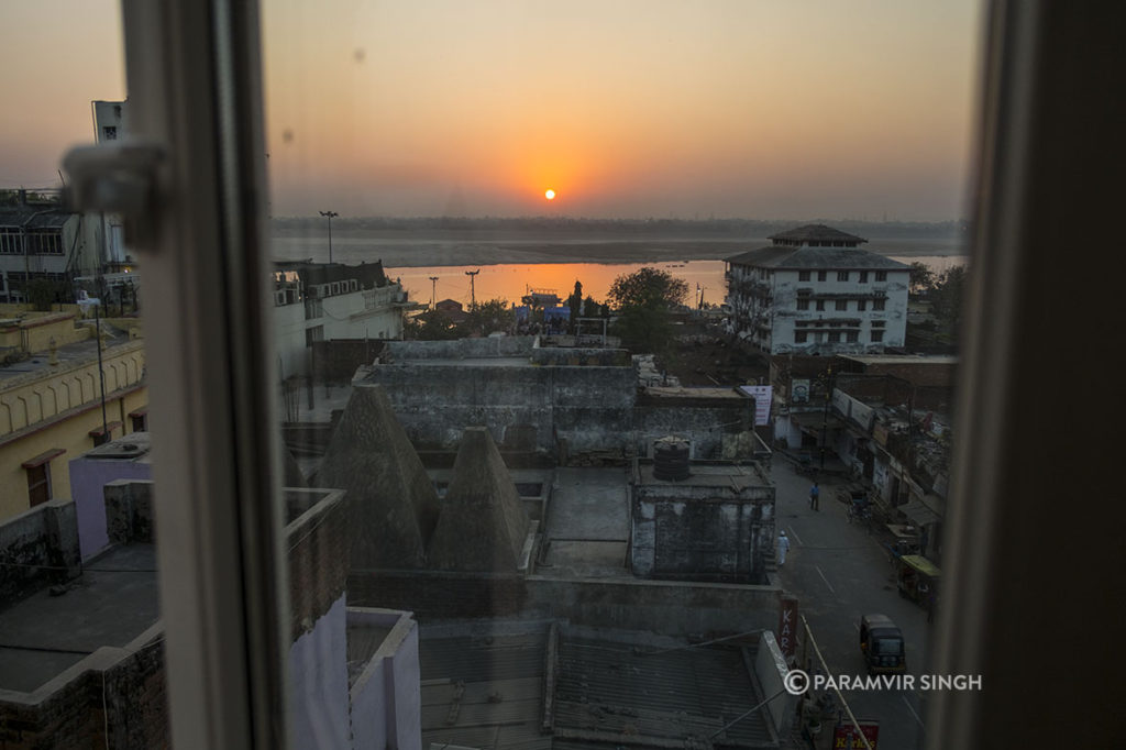 The morning sun rises behind the Ganges in Varanasi